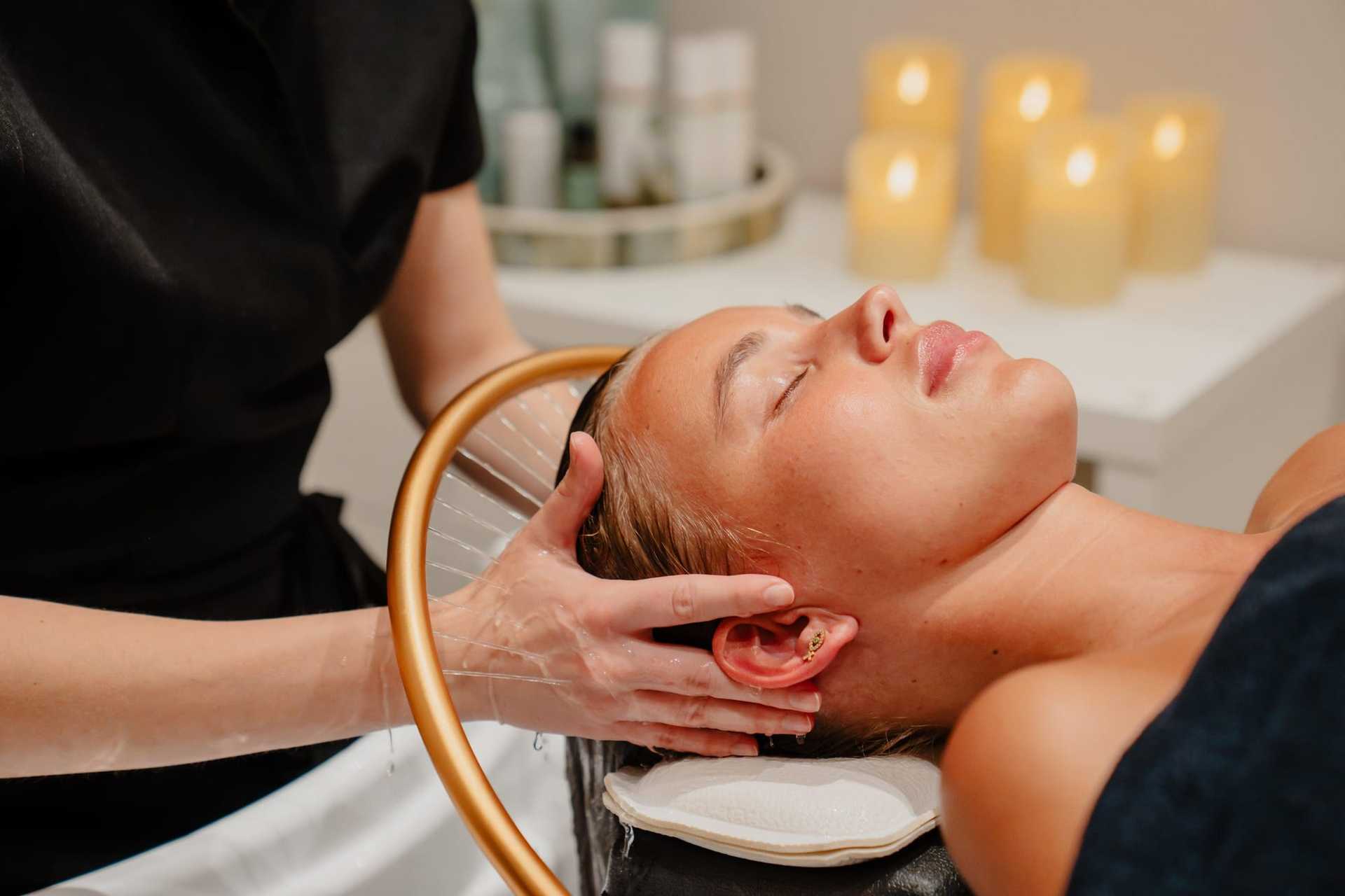 Massage therapist giving a relaxing facial treatment in a spa atmosphere.